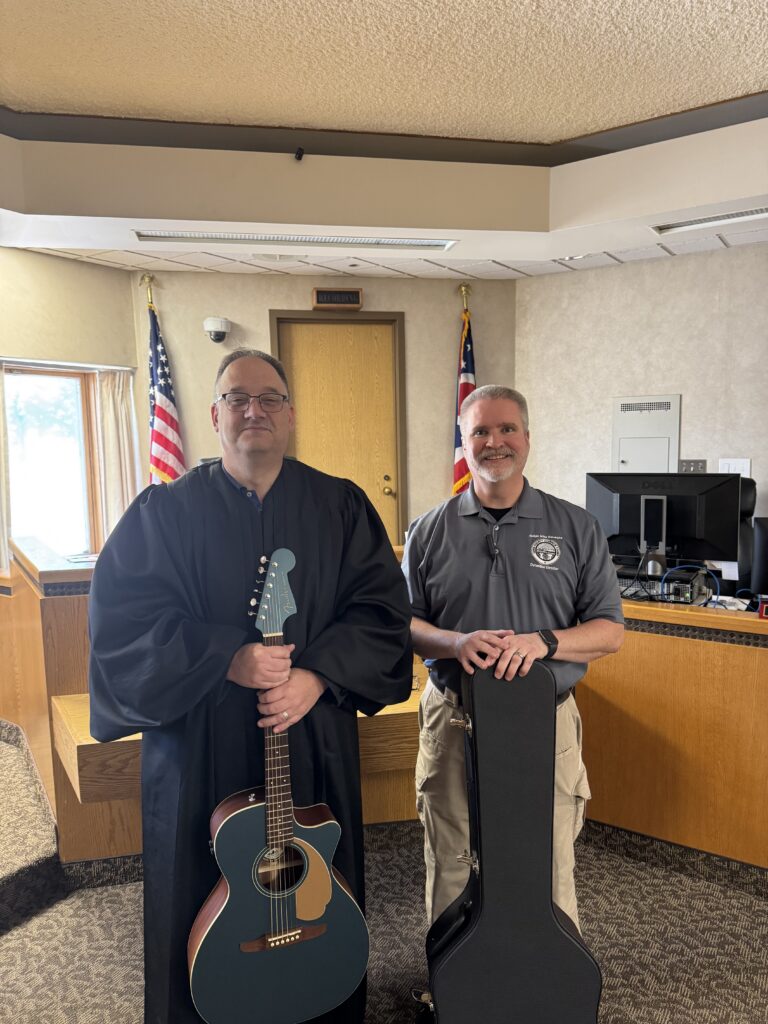 Judge DeLeone and Tim Brown with donated guitar